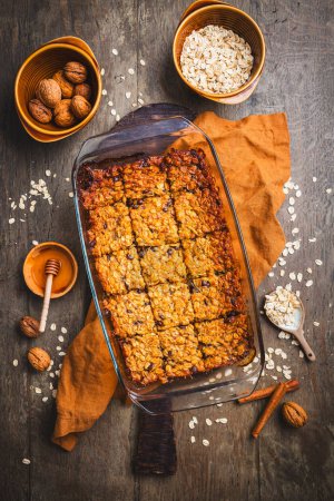 Photo for Vegan oatmeal banana bread or case with nuts on wooden kitchen table - Royalty Free Image