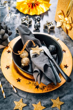 Photo for Place setting in golden and black tone for Christmas, New Year - Royalty Free Image