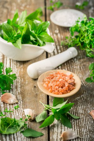 Photo for Thai basil and spicy herbs with Himalayan salt for healthy cooking on wooden table - Royalty Free Image