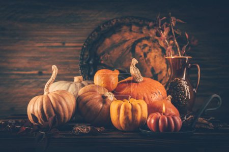 Photo for Autumn still life with pumpkins and candles on wooden background. Thanksgiving home decoration. - Royalty Free Image