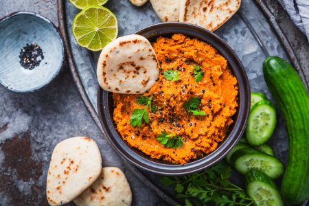 Téléchargez les photos : Tartinade ou trempette aux carottes et lentilles Harissa végétalienne maison avec pain plat et concombre - en image libre de droit