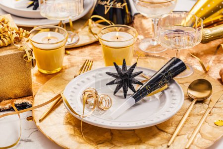 Foto de Celebración de Año Nuevo. Mesa de fiesta servida con champán y cubiertos de oro de lujo, con decoración y decoración navideña - Imagen libre de derechos
