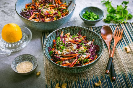 Photo for Red cabbage salad in Asian style with carrots, cilantro, cashew nuts and onions - Royalty Free Image