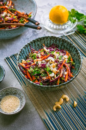 Téléchargez les photos : Salade de chou rouge de style asiatique avec carottes, coriandre, noix de cajou et oignons - en image libre de droit