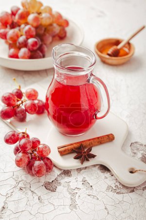 Téléchargez les photos : Vinaigre rouge bio maison à la cannelle et à l'anis. Vinaigre balsamique de raisin rouge à base de raisins frais fermentés. - en image libre de droit