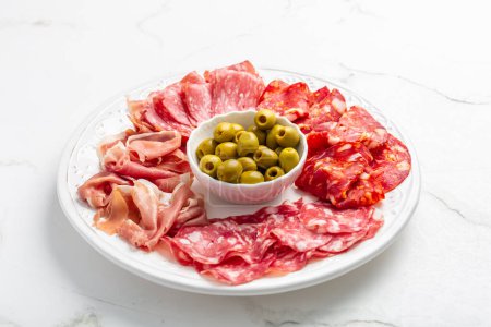 Téléchargez les photos : Assortiment d'entrées de viande italiennes et espagnoles, de prosciutto, de salami et de jambon, avec olives - en image libre de droit