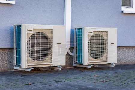 Téléchargez les photos : Deux pompes à chaleur à source d'air installées en dehors de la maison de ville neuve et moderne, concept d'énergie renouvelable verte de la pompe à chaleur - en image libre de droit