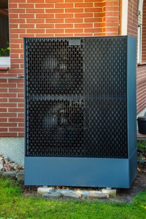 Téléchargez les photos : Pompe à chaleur à source d'air installée à l'extérieur dans un jardin, concept d'énergie renouvelable verte de la pompe à chaleur - en image libre de droit