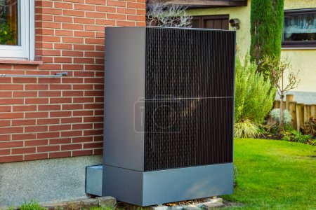 Téléchargez les photos : Pompe à chaleur à source d'air installée à l'extérieur dans un jardin, concept d'énergie renouvelable verte de la pompe à chaleur - en image libre de droit