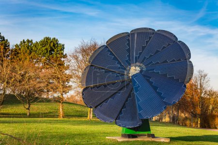 Photo for Rotating solar panel in flower shape in a city park. Photovoltaic, alternative electricity source - Royalty Free Image