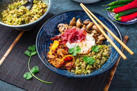 Photo for Ketogenic diet bowl with organic cauliflower and broccoli rice, stir fried chicken, mushrooms, egg and onions. Gluten free healthy food. - Royalty Free Image