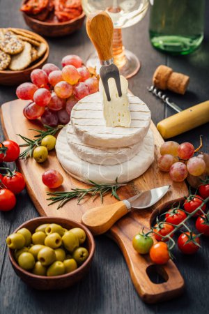 Foto de Bandeja de queso con brie, Camembert, uvas, aceitunas y tomates - Imagen libre de derechos