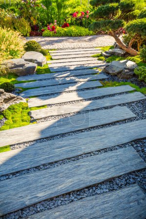 Téléchargez les photos : Chemin de pierre zen dans un jardin japonais avec paillis de gravier et d'écorce et plantes indigènes - en image libre de droit