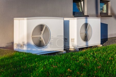 Téléchargez les photos : Deux pompes à chaleur à source d'air installées à l'extérieur d'une maison moderne - en image libre de droit