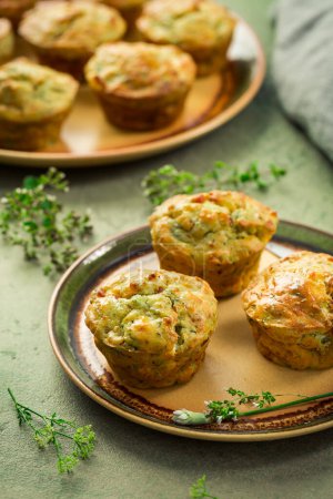 Photo for Homemade savory muffins with zucchini and cheese on kitchen table - Royalty Free Image