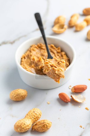 Photo for Bowl with homemade crunchy peanut butter and heap of nuts - Royalty Free Image