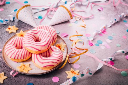 Foto de Donuts para carnaval y fiesta. Krapfen alemán o rosquillas con serpentinas y confeti. Colorido carnaval o imagen de cumpleaños - Imagen libre de derechos