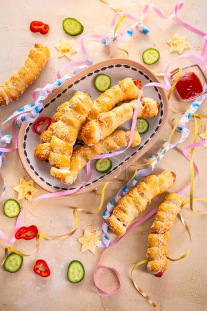 Téléchargez les photos : Couverture de porc, longues saucisses enveloppées dans de la pâte à levure - carnaval traditionnel, Fasching et nourriture de fête - en image libre de droit