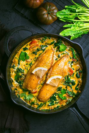 Téléchargez les photos : Curry rouge aux épinards, lait de coco et poisson cuit dans une casserole - en image libre de droit