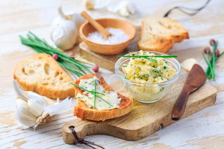 Photo for Homemade garlic butter with chives and fresh roasted baguette with salt - Royalty Free Image