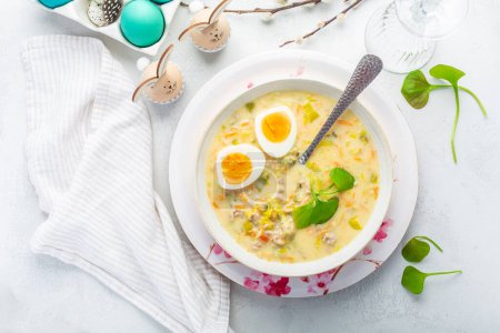 Photo for Homemade polish Easter soup with addition of sausage, hard boiled egg and vegetables in a bowl - Royalty Free Image