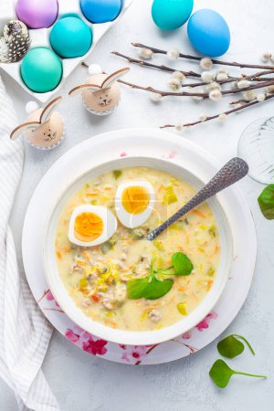 Homemade polish Easter soup with addition of sausage, hard boiled egg and vegetables in a bowl