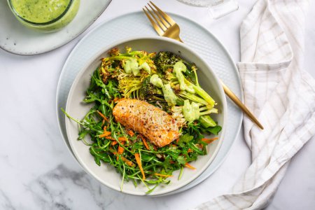 Photo for Grilled salmon fillet with parmesan broccoli and fresh vegetable salad, avocado dressing. Mediterranean diet. - Royalty Free Image