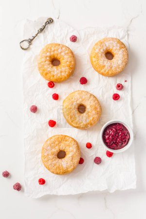 Foto de Cronuts - deliciosa fusión de croissant y donut con mermelada de frambuesa. Pastelería a medio donut y medio croissant - Imagen libre de derechos