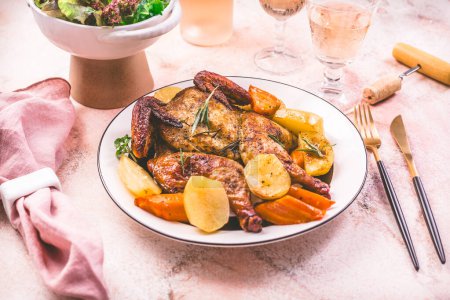 Téléchargez les photos : Poulet rôti avec pommes de terre, légumes et salade sur une table - en image libre de droit