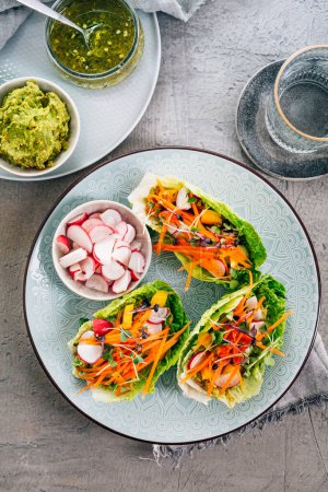 Photo for Vegan lettuce wraps with vegetables, avocado spread and microgreens, healthy snack - Royalty Free Image