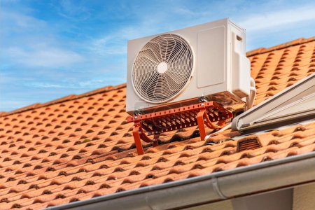 Téléchargez les photos : Compresseur double onduleur, combinaison de compresseur de climatiseur et pompe de chauffage, installé sur un toit de la maison familiale. - en image libre de droit