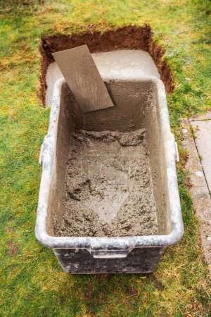 Photo for Mixed concrete in a bucket, construction work in a garden - Royalty Free Image