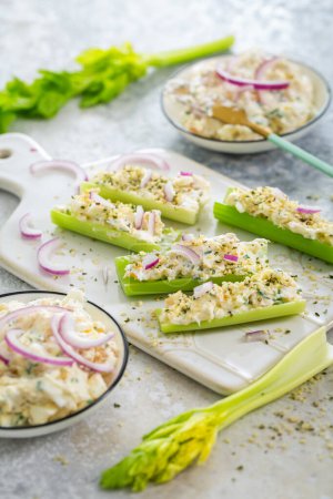 Photo for Celery sticks filled with egg and tuna salad, healthy vegetable and antipasti snack - Royalty Free Image