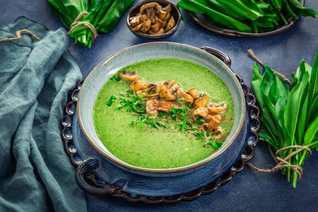 Photo for Creamy homemade bear leek soup or ramson soup with fried champignons - Royalty Free Image