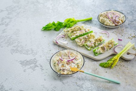Téléchargez les photos : Bâtonnets de céleri remplis d'œufs et de salade de thon, de légumes sains et de collations antipasti - en image libre de droit