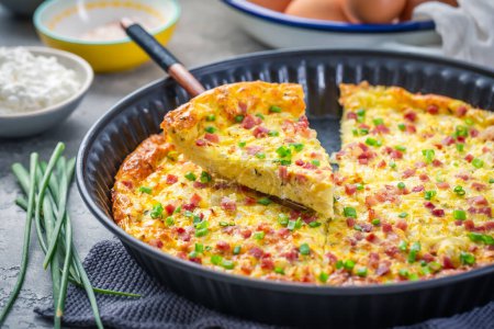 Photo for Homemade oven baked frittata with curd cheese, bacon, onion and chives - Royalty Free Image