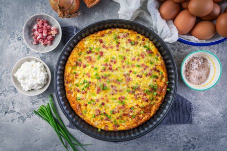 Photo for Homemade oven baked frittata with curd cheese, bacon, onion and chives - Royalty Free Image