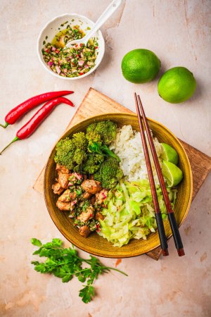Foto de Tazón de pollo con arroz, brócoli, col y salsa Chimmichurri verde - Imagen libre de derechos