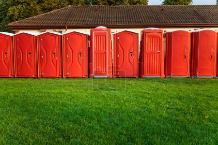Tragbare rote Toiletten aus Plastik im Park - mobiles Sanitärsystem