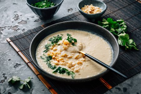 Photo for Spicy and creamy cauliflower and coconut soup with cilantro and macadamia nuts - Royalty Free Image