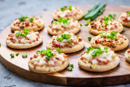 Photo for Small French dish tarte flambee cream cheese, bacon and onions. Flammkuchen from Alsace region. - Royalty Free Image