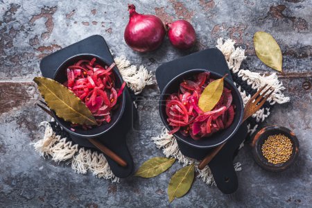 Foto de Cebollas rojas en escabeche en un tazón sobre un fondo gris. Aperitivo, condimento o aderezo, alimentos fermentados saludables. - Imagen libre de derechos