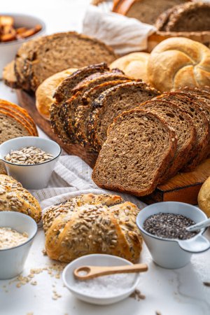 Foto de Surtido de pan, panecillos y productos de panadería con sal y semillas - Imagen libre de derechos