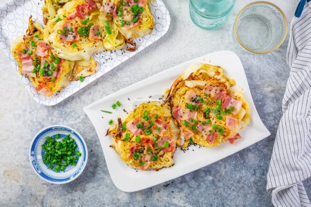 Oven baked cabbage steaks with parmesan, bacon and green onions