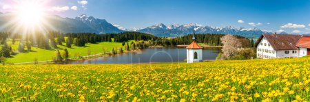 Téléchargez les photos : Paysage panoramique avec lac, chaîne de montagnes et soleil sur le ciel - en image libre de droit
