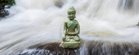 Photo for Buddha sculpture sitting in flowing water cascade - Royalty Free Image