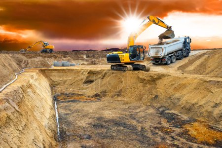 Téléchargez les photos : Excavatrice travaille et creuse sur le chantier de construction - en image libre de droit