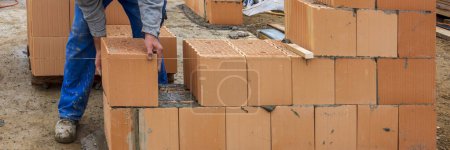 Téléchargez les photos : Bricklayer at work at new house in construction - en image libre de droit
