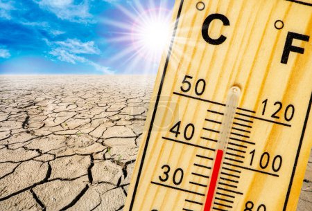 Photo for Thermometer shows high temperature in summer heat with dryness and lack of water in field - Royalty Free Image