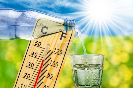 Téléchargez les photos : Thermomètre montre une température élevée dans la chaleur d'été et bouteille avec de l'eau et verre à boire - en image libre de droit